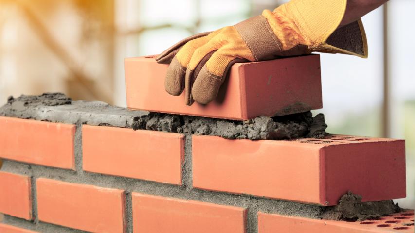 A hand showing brick layering construction